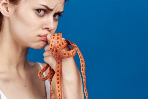 A woman with a measuring tape in her hands.