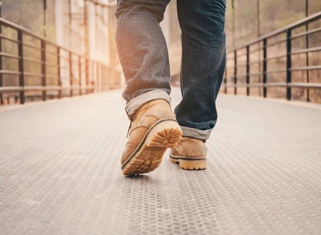 Travel concept. Men wear leather shoes and travel on the Suspension bridge.