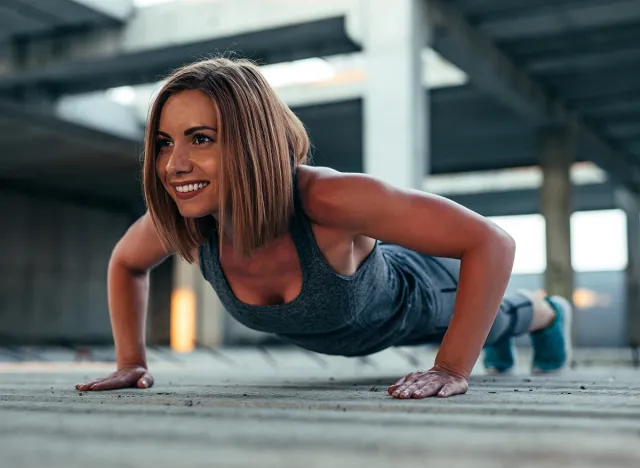 Shot of a beautiful athlete woman doing push ups in an abandoned building.
