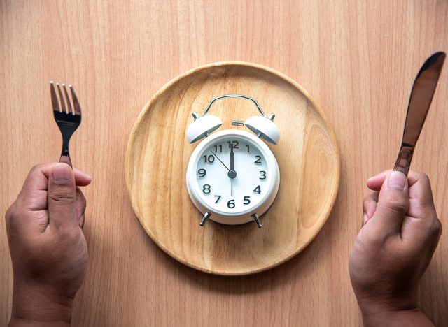 The clock is at 12:00 noon for lunch in a wooden dish.