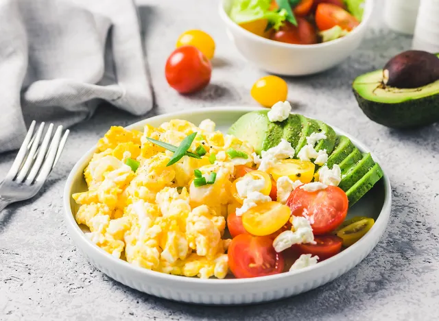 Scrambled eggs with cherry tomatoes , avocado feta cheese and olive oil.Selective focus, space for text.