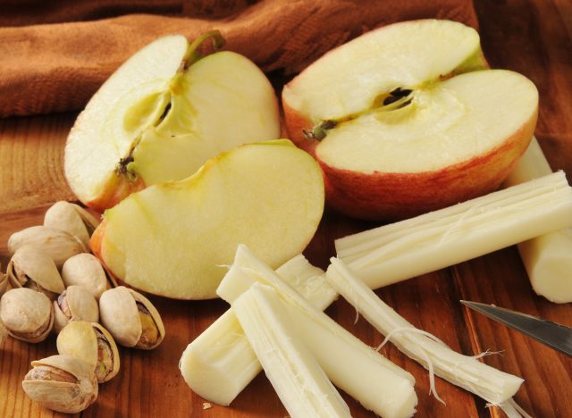 A healthy snack with pistachio nuts, apples and string cheese