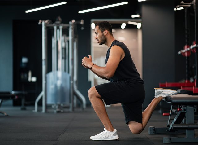 Portrait Of Athletic Black Man Making Bulgarian Split Squat Exercise At Gym, Motivated Young African American Male Training On Leg Muscles At Modern Sport Club, Enjoying Bodybuilding, Side View