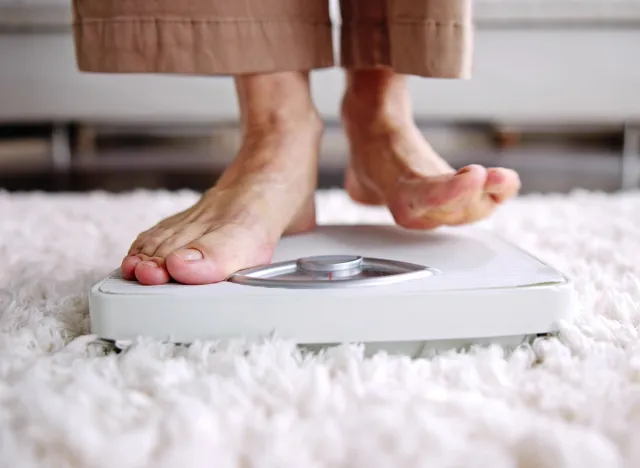 Low Section Of Woman Standing On Weight Scale