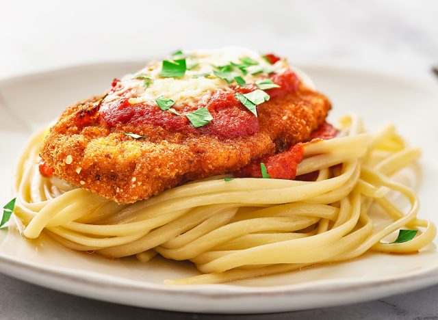 Close up Chicken Parmesan and spaghetti in a plate. Low angle view. Macro shot with focus stacking.