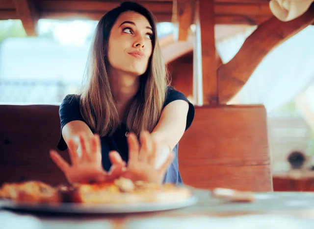 Unhappy Woman refusing to Eat her Pizza Dish in a Restaurant. Disgruntled customer not liking the meal sending it back