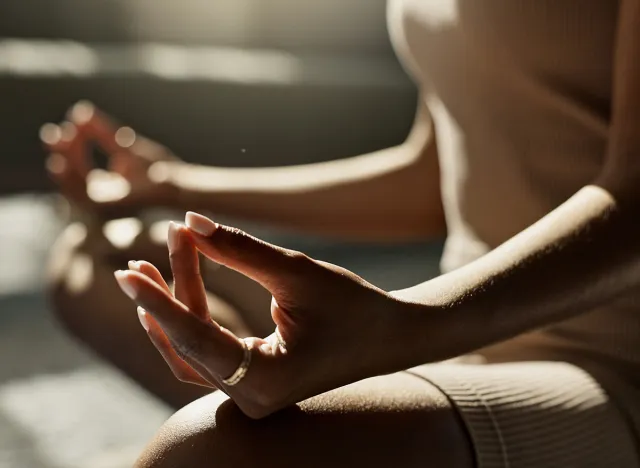Meditation, hands woman in lotus pose on a floor for peace, zen or mental health wellness at home. Breathing, relax and female person in living room for energy training, exercise or holistic practice