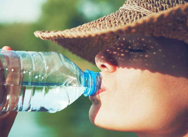 Woman drinking water in summer sunlight