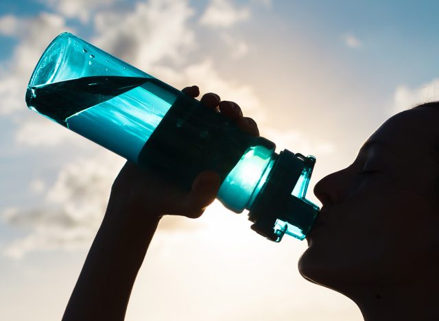 Woman drinking water from a sports bottle.