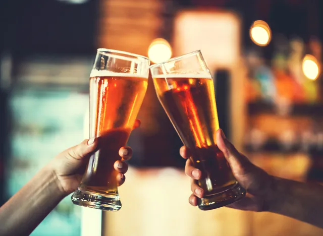 Two friends toasting with glasses of light beer at the pub. Beautiful background of the Oktoberfest. fine grain. Soft focus. Shallow DOF