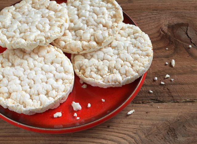 Round rice cakes in red plate on wooden background close up