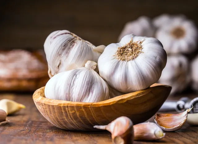 Garlic Cloves and Bulb in vintage wooden bowl.