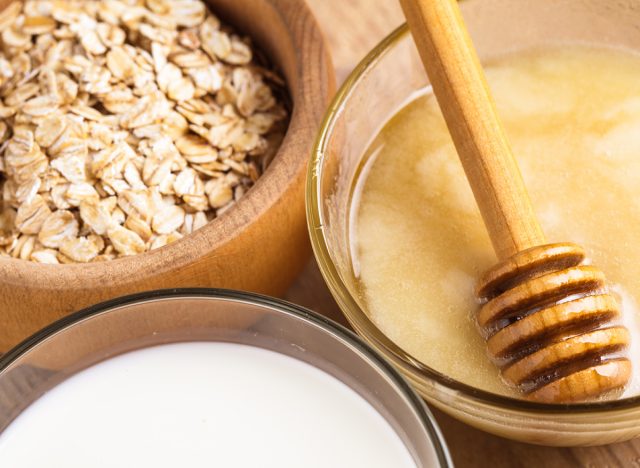 Milk and honey on the wooden table closeup