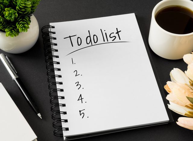 To do list. Notebook and coffee cup on black background.