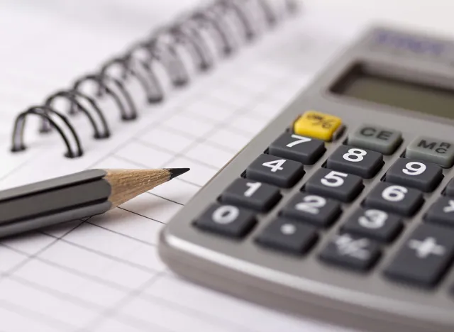 Gray pencil, calculator and opened account book