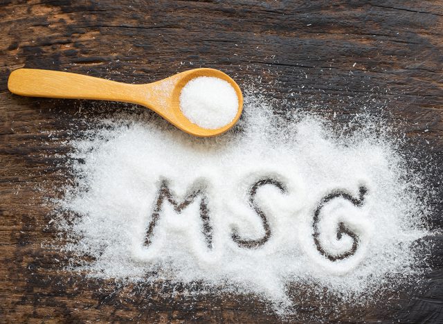 Monosodium glutamate, MSG on wooden spoon. Copy space., a flavor enhancer in many asian food