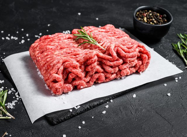 Raw minced pork. Black background. Top view. Space for text