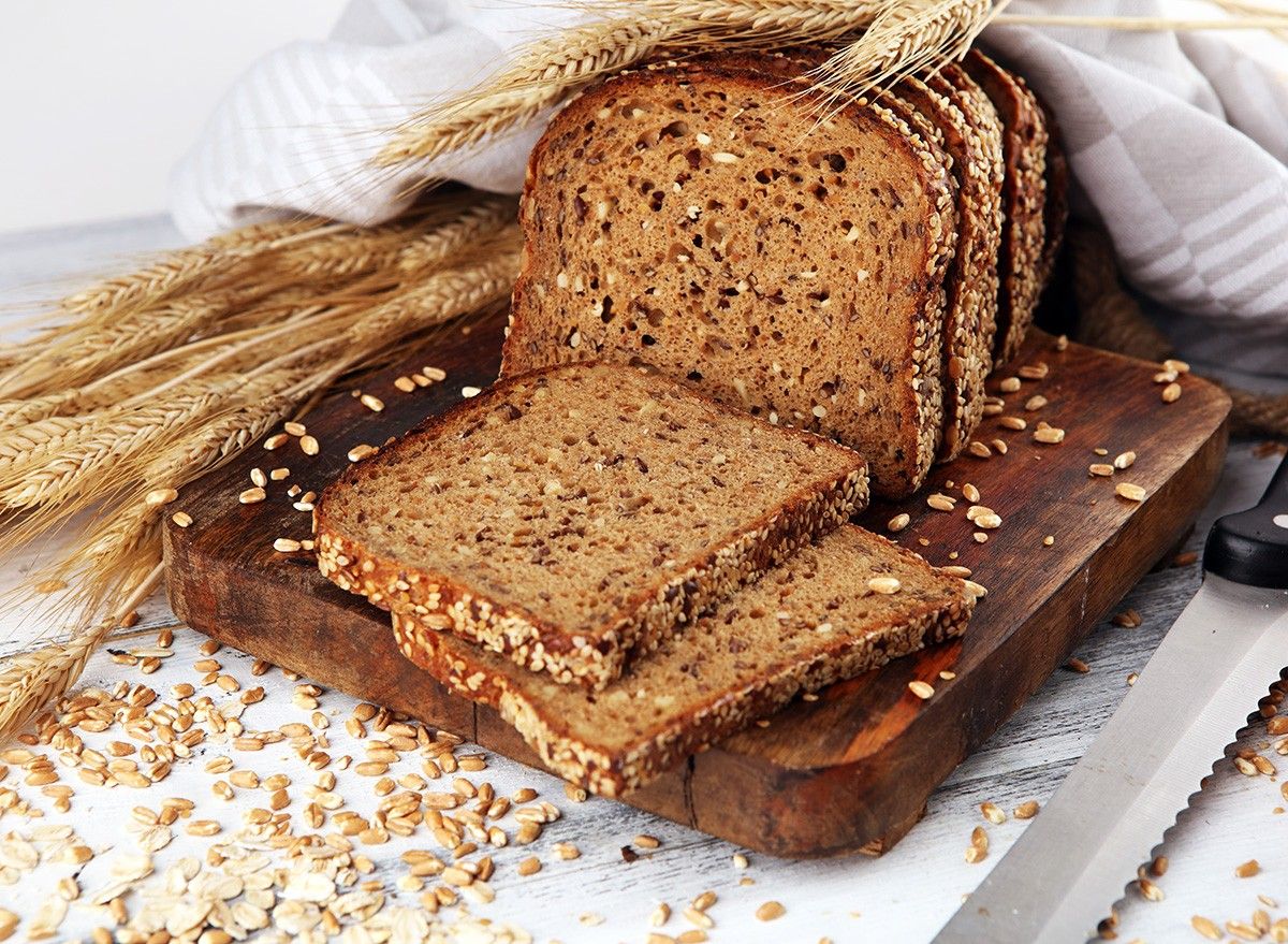 Sliced rye bread on cutting board. Whole grain rye bread with seeds on rustic background