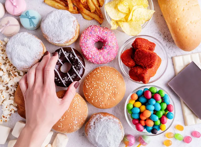 Fast food concept. Unhealthy food. Unhealthy food and fast food with donuts, chocolate, burgers and sweets top view