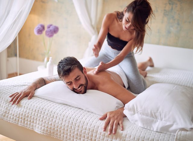 caucasian female giving massage to a young man. leisure, fun, joy, relaxing, concept