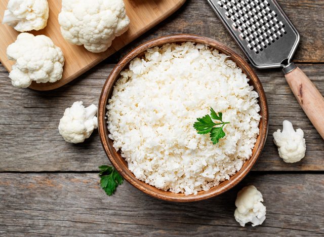 Freshly grated raw cauliflower rice in wooden bowl
