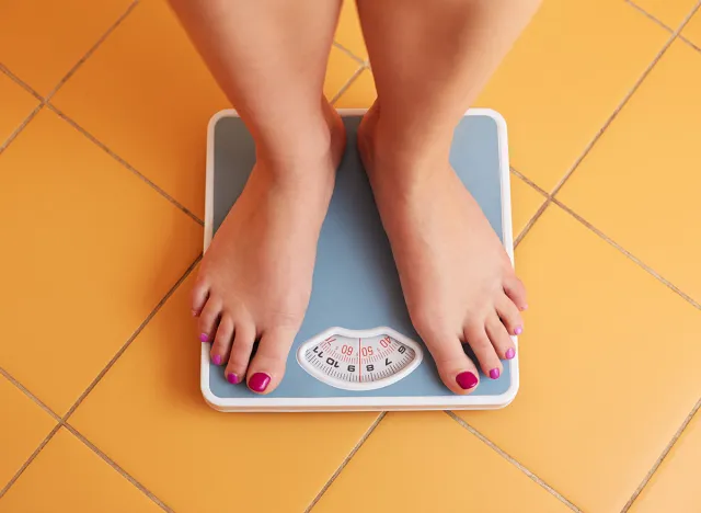 A pair of female feet standing on a bathroom scale