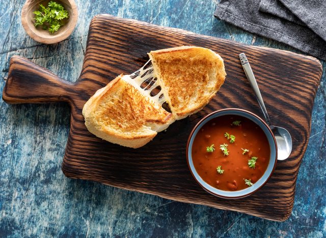 Top down view of a grilled cheese sandwich with tomato soup, ready for eating.