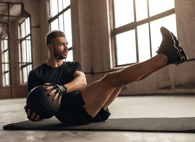 Man doing core exercise with medicine ball