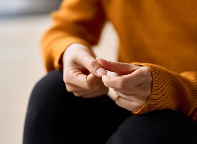 Hands of a woman playing with nails in stress