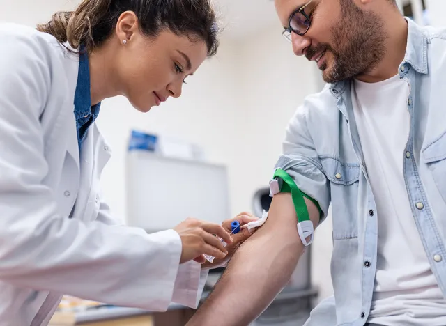 Preparation for blood test by female doctor medical uniform on the table in white bright room. Nurse pierces the patient's arm vein with needle blank tube.