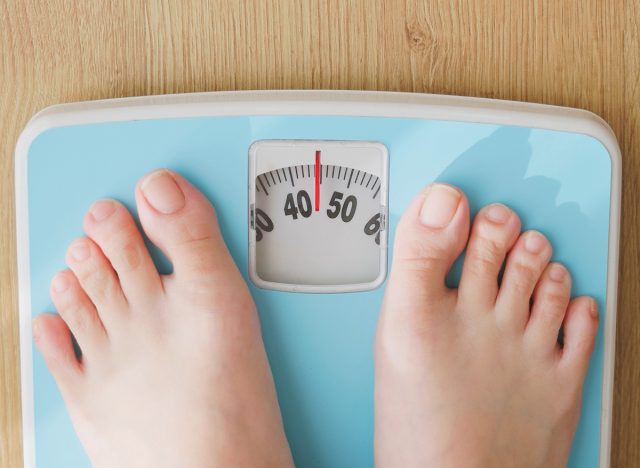 point of view - closeup feet for asian woman measure weight on scale