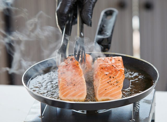 chef cooking salmon steaks in the kitchen