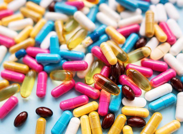 Lots of colorful pills and capsules for different symptoms. Selective focus, noise. Concept of health and medicine