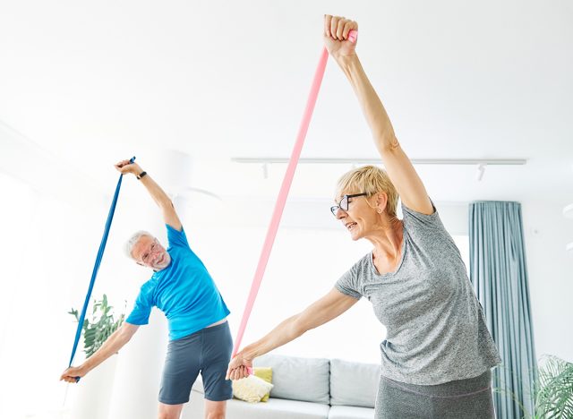 Senior couple exercise stretching resistance band at home, health care and active seniors concept