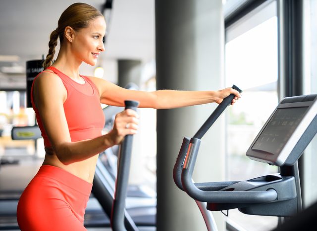 Woman exercising in a gym with an elliptical cross trainer