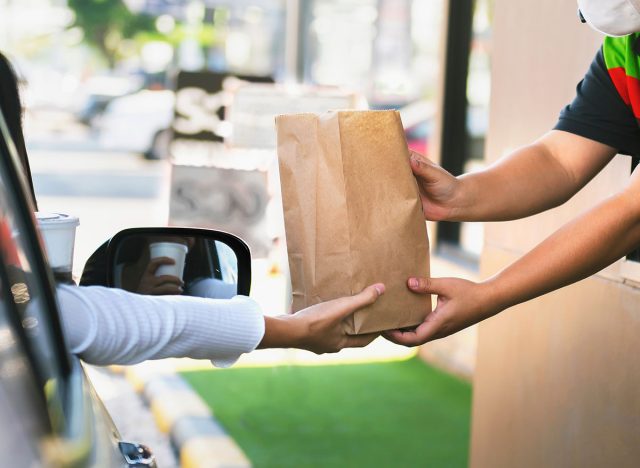 Woman getting fast food at drive-thru