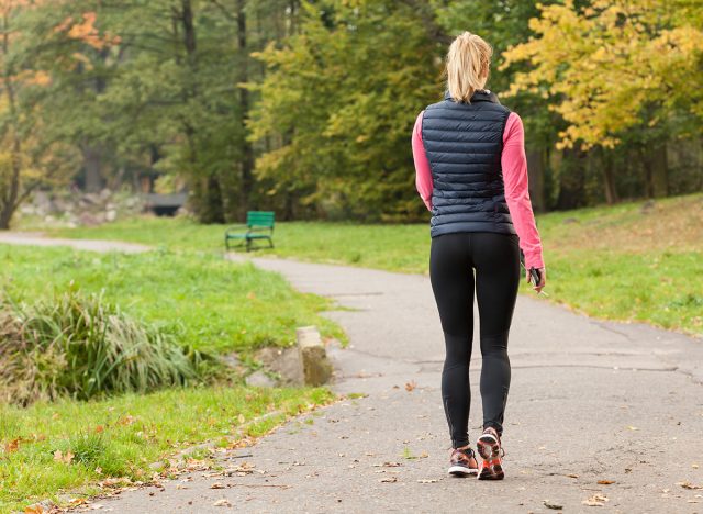 Fit woman walking in park during autumn time