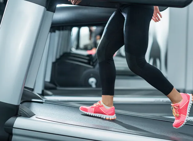 Woman using incline threadmill in modern gym. Incline threadmills are used to simulate uphill walking or running and deliver additional workout benefits to users.