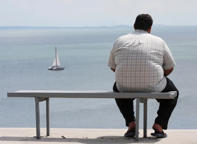 A man sitting on the bench and looking at the sea