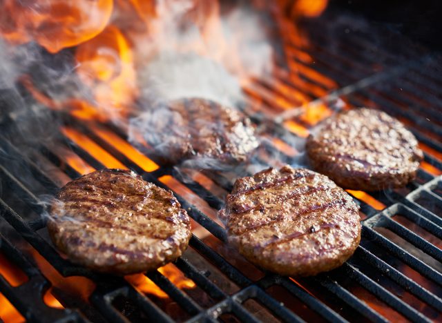 cooking burgers on hot grill with flames