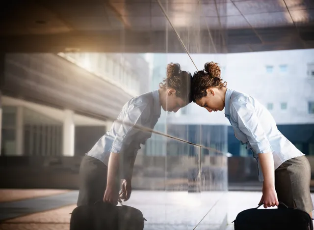 mid adult italian woman banging her head against a wall outside office building. Horizontal shape, copy space