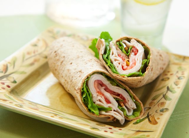 healthy turkey wrap sandwich with lettuce, tomato, onion and peppers