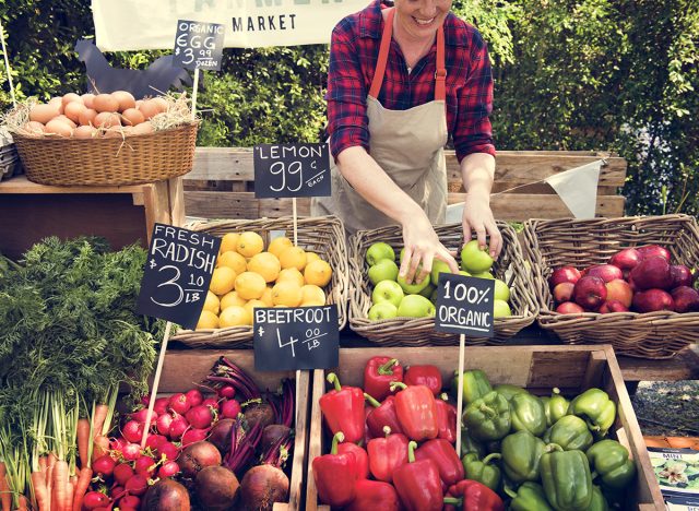 Greengrocer preparing organic fresh agricultural product at farmer market