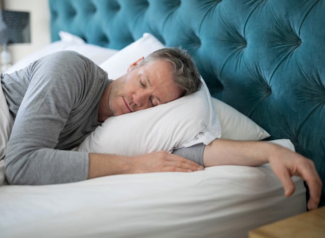 Man sleeping on bed in bedroom at home