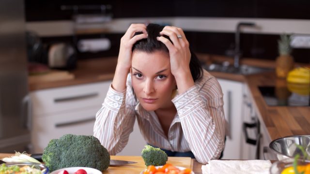 Depressed and sad young woman in kitchen