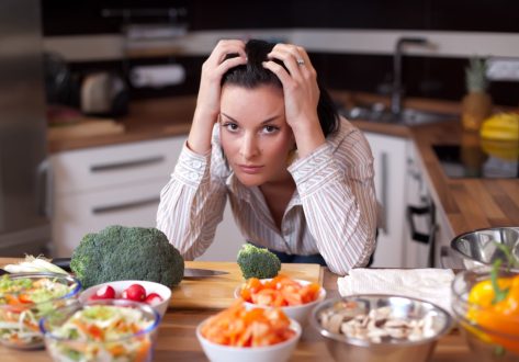 Depressed and sad young woman in kitchen