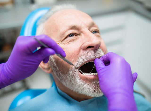 Senior man having dental treatment at dentist's office.