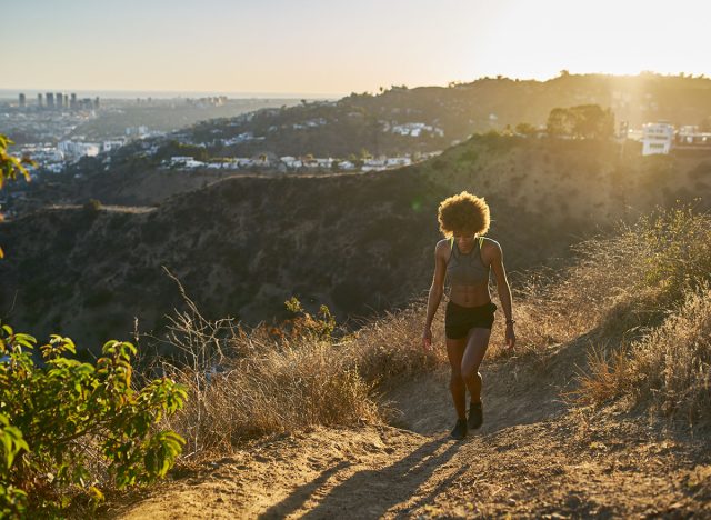 fit african american woman hiking up runyon canyon at sunset