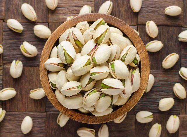 pistachio in shell nuts in bowl on wooden table background.