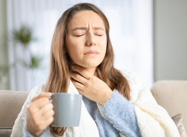 Young woman touching painful neck, sore throat for flu, cold and infection